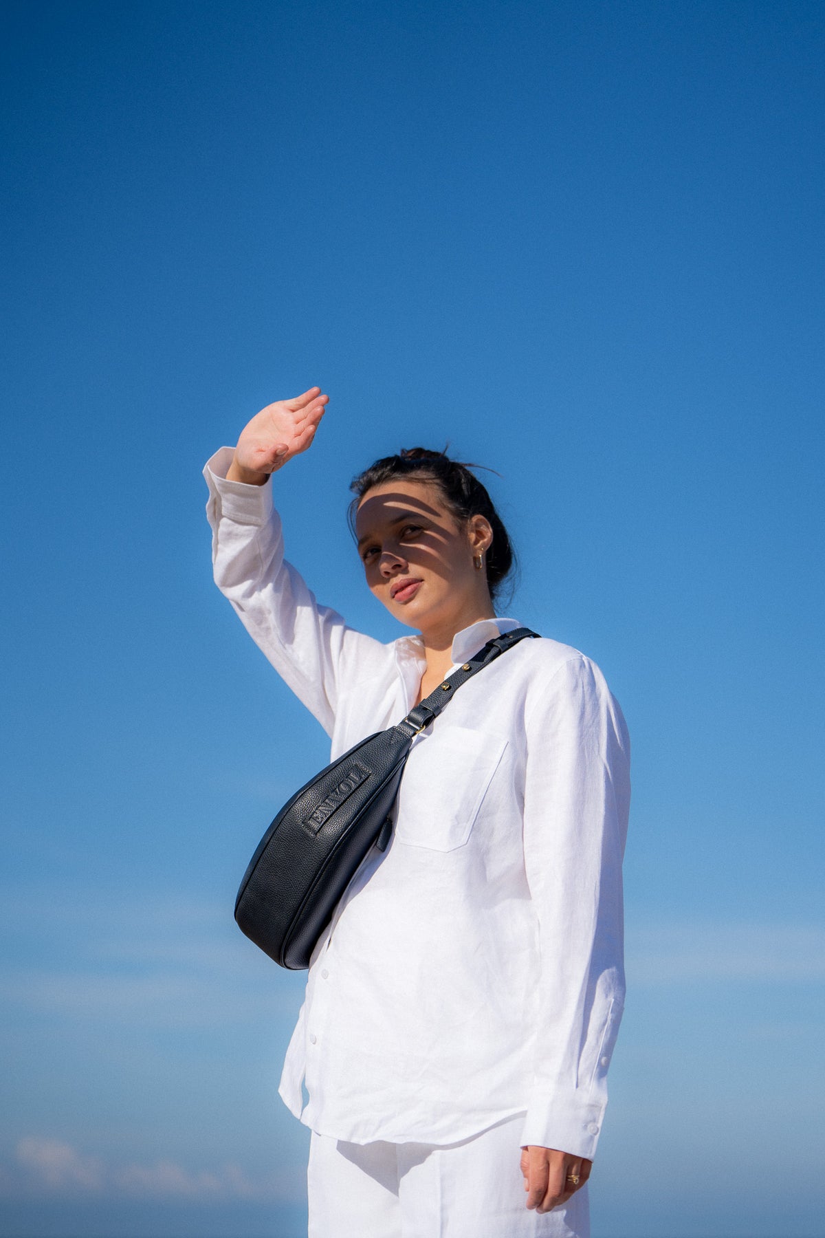 Femme portant le sac banane Thelma ENVOL bleu de cendre sous un ciel bleu #Couleur_Bleu de Cendre