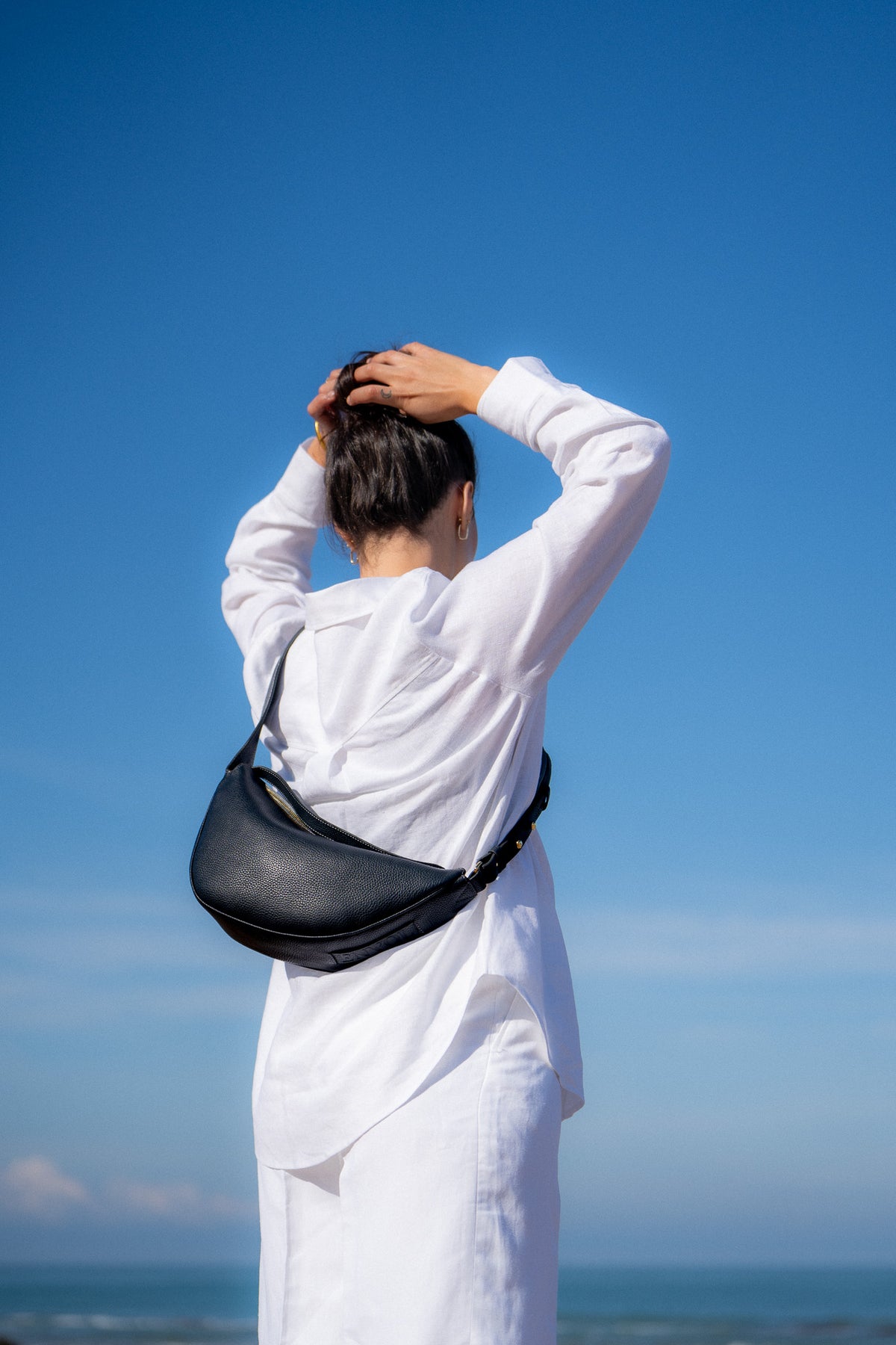 Femme portant le sac banane Thelma ENVOL bleu de cendre bras levé #Couleur_Bleu de Cendre