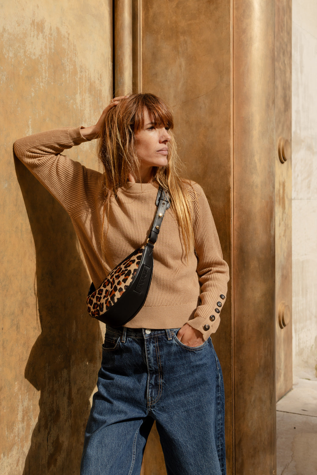Femme portant le mini sac banane Lou ENVOL imprimé léopard en ville, de profil #Couleur_Léopard