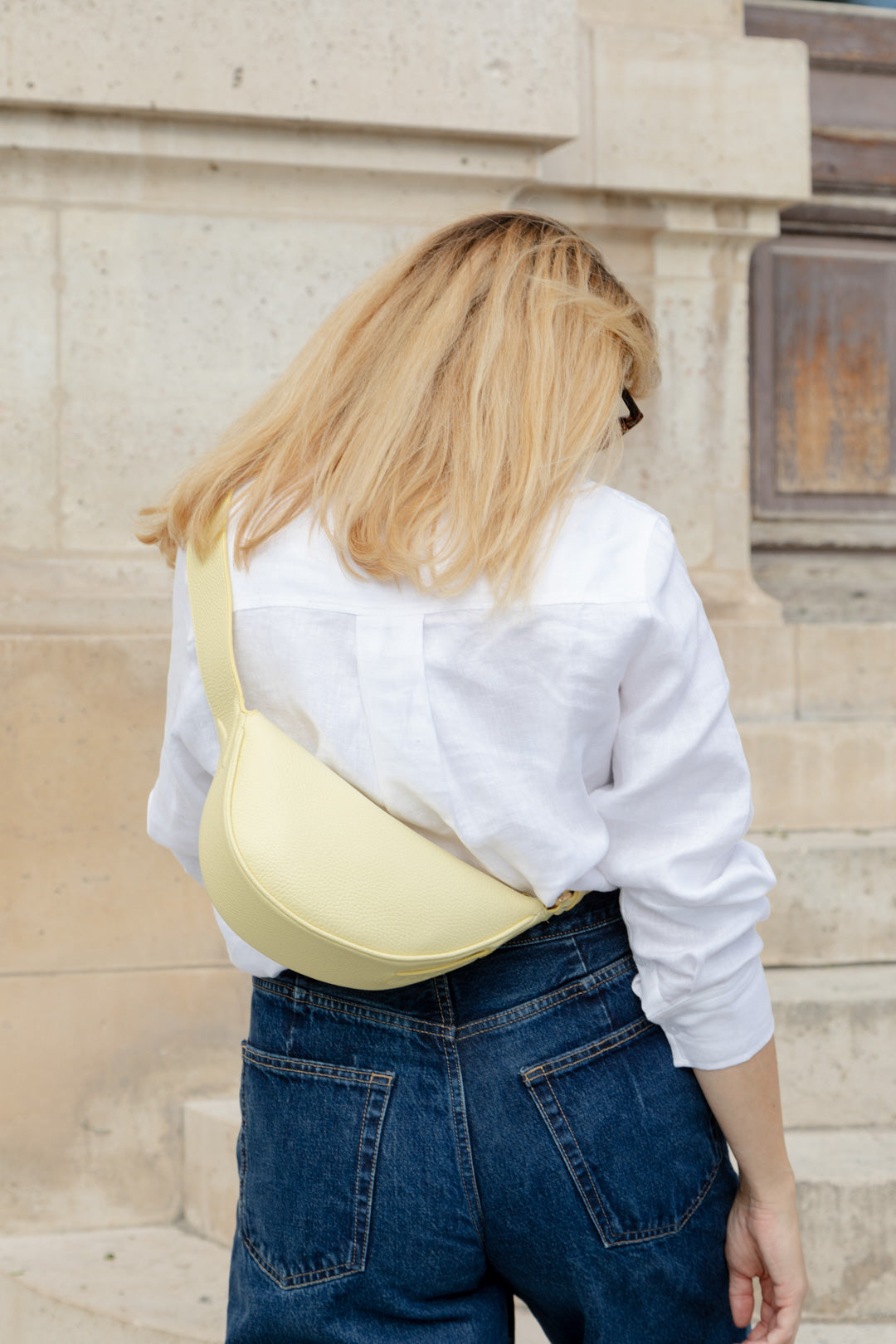 Femme portant le mini sac banane Lou ENVOL jaune pastel de dos #Couleur_Jaune Pastel