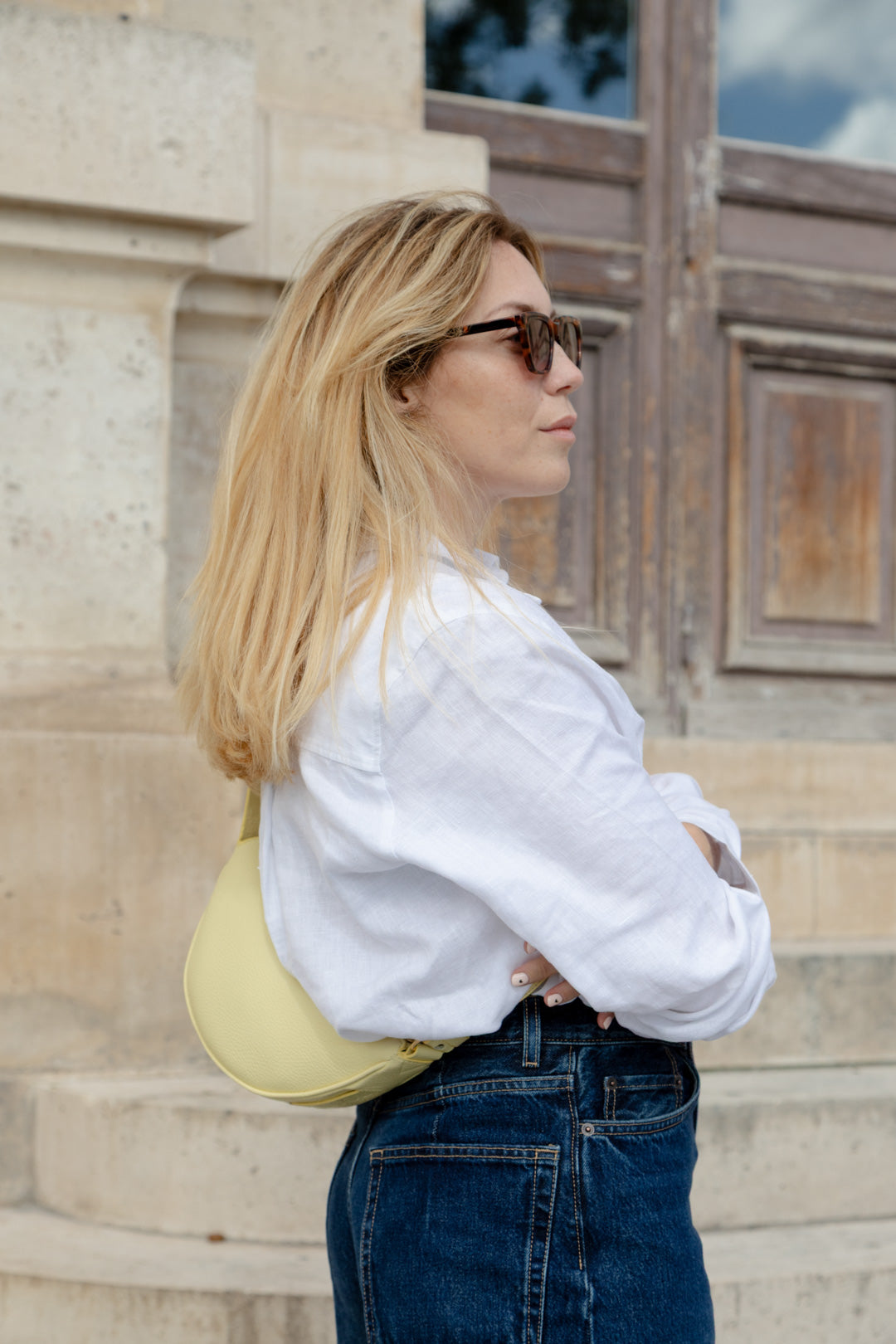 Femme portant le mini sac banane Lou ENVOL jaune pastel en ville #Couleur_Jaune Pastel