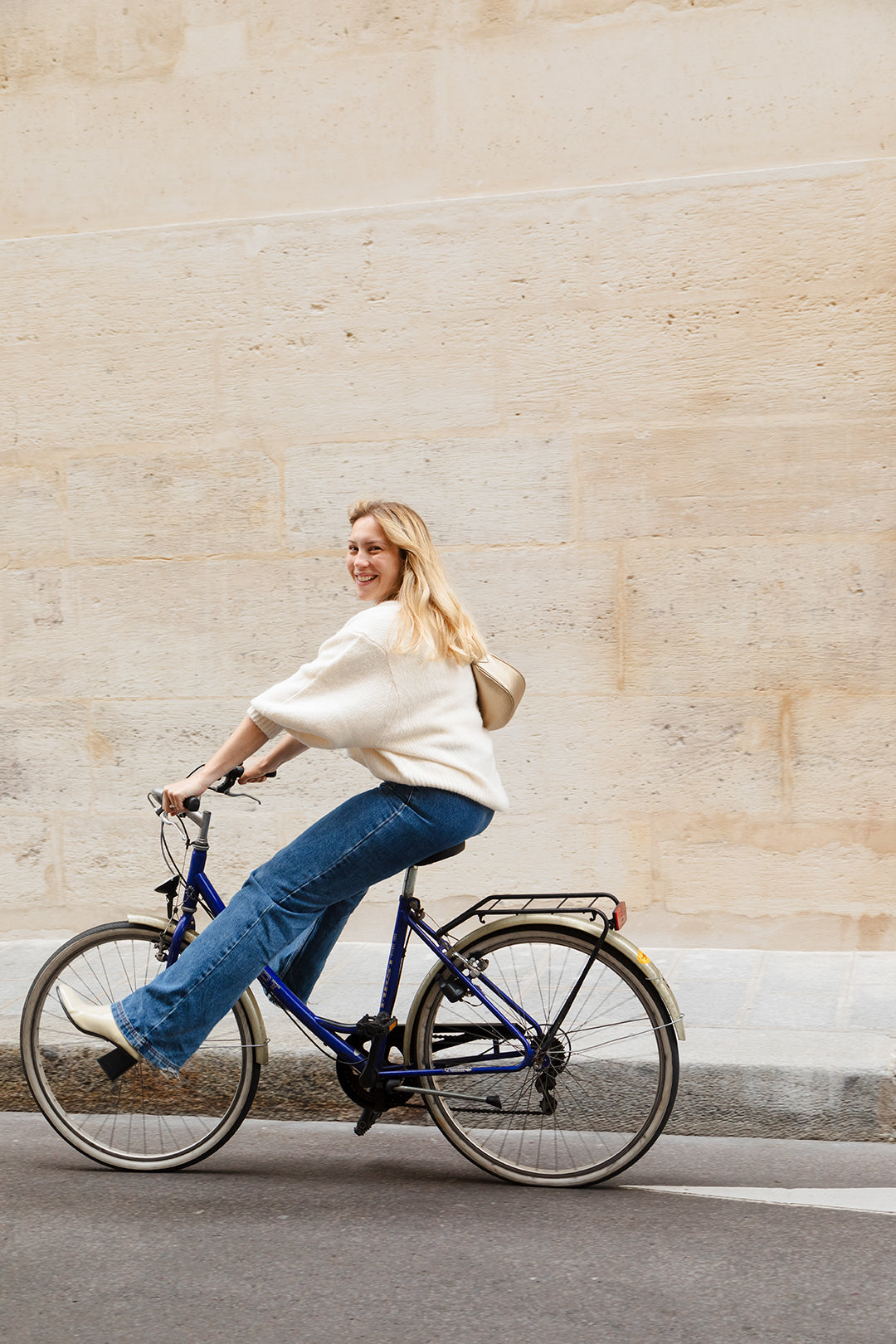 Femme portant le mini sac banane Lou ENVOL doré à vélo #Couleur_Gold