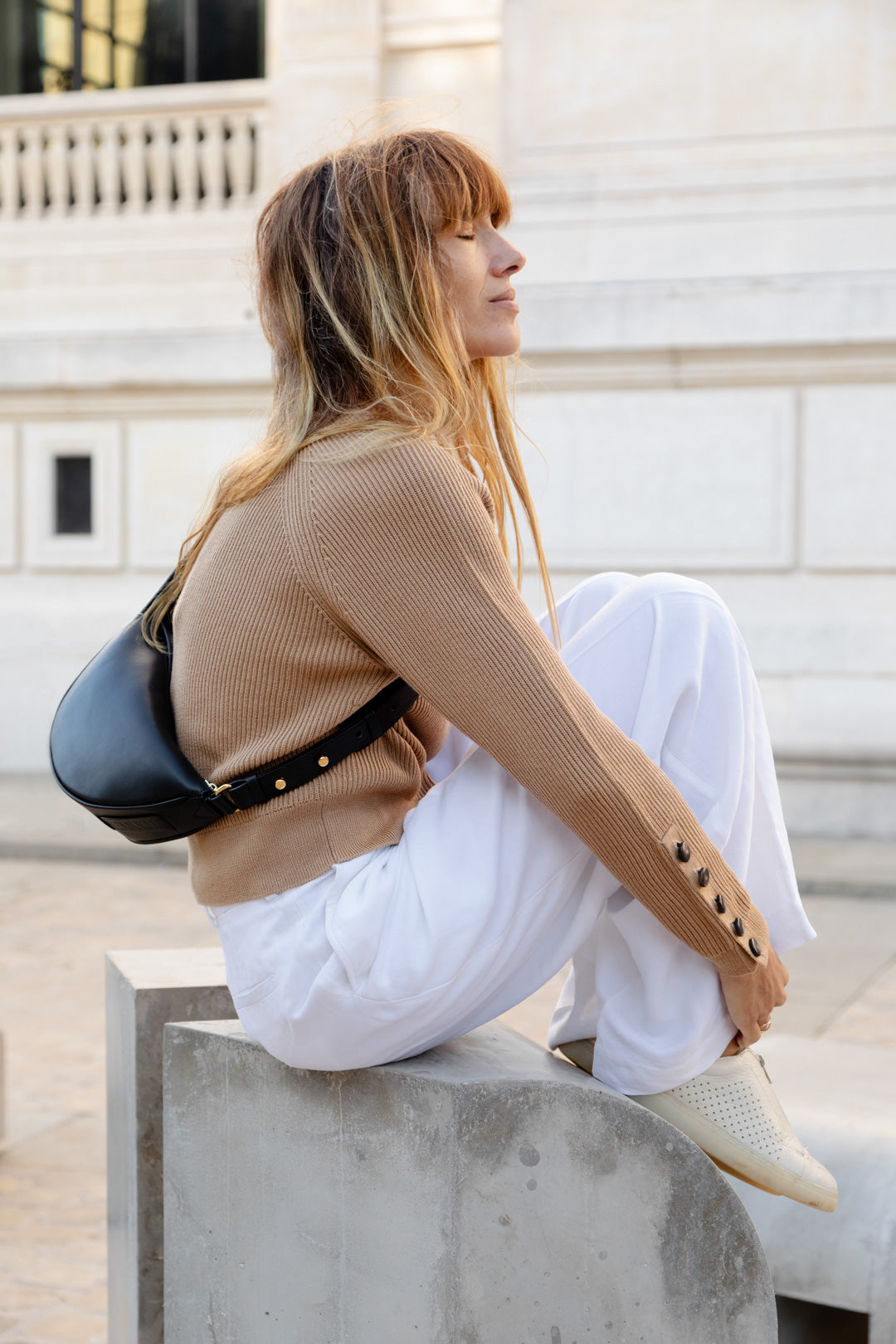 Femme portant le mini sac banane Lou ENVOL noir assise en ville #Couleur_Noir