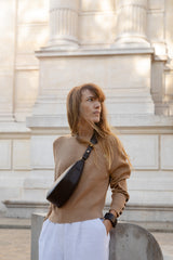 Femme portant le bracelet Ava ENVOL noir avec le sac banane Thelma noir #Couleur_Noir