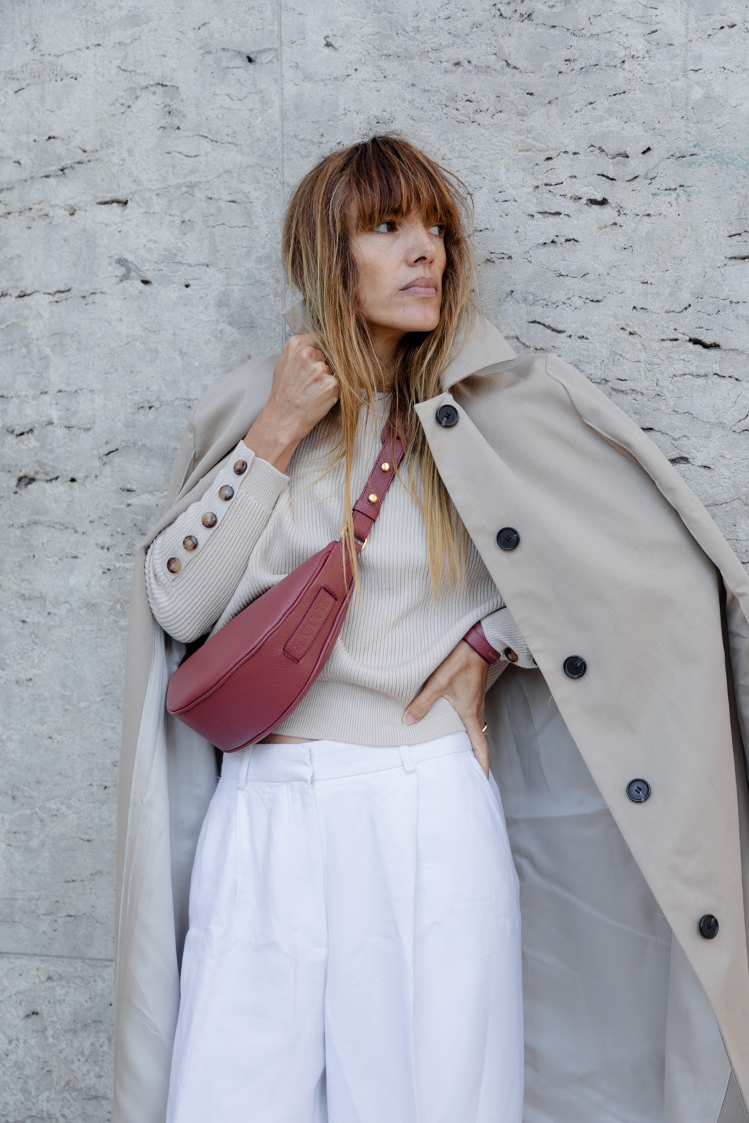 Femme portant le mini sac banane Lou ENVOL bois de rose avec un trench #Couleur_Bois de Rose