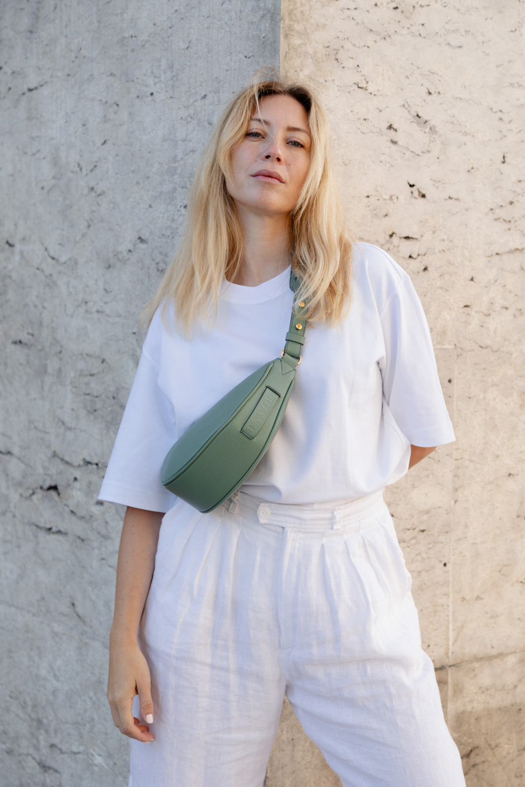 Femme portant le mini sac banane Lou ENVOL vert amande en bandoulière #Couleur_Vert Amande