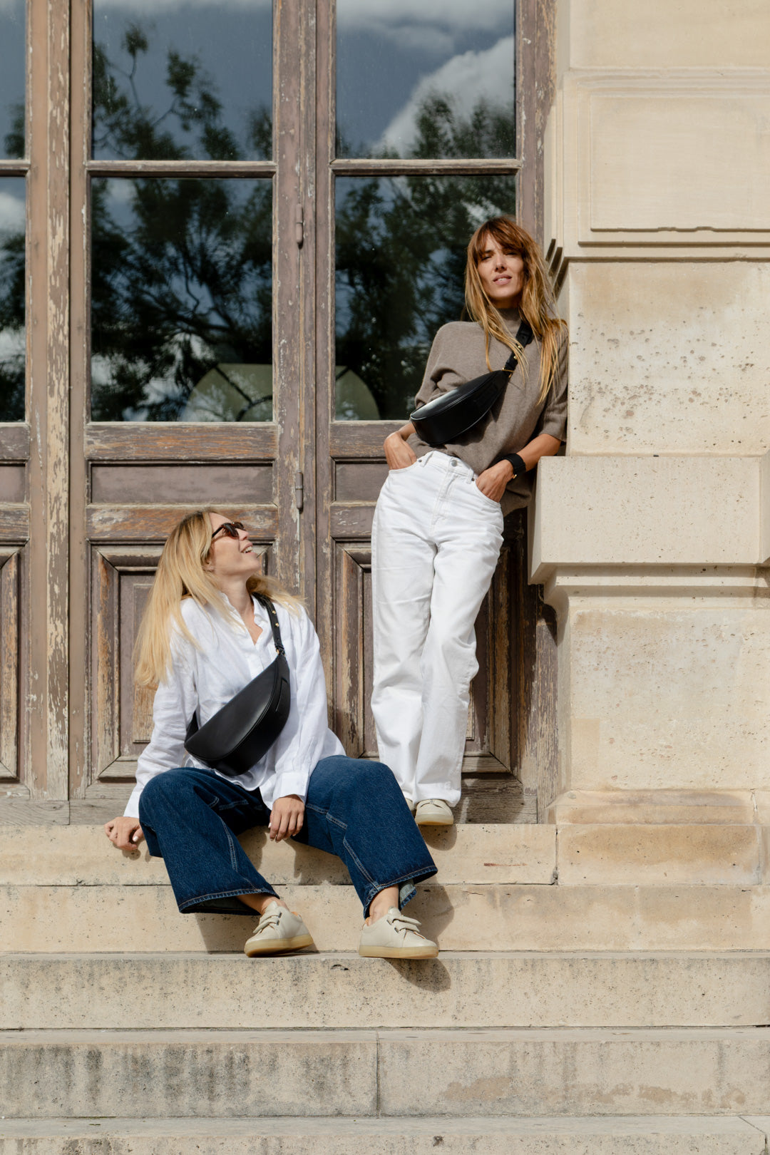 Deux femmes portant le mini sac banane Lou ENVOL noir #Couleur_Noir