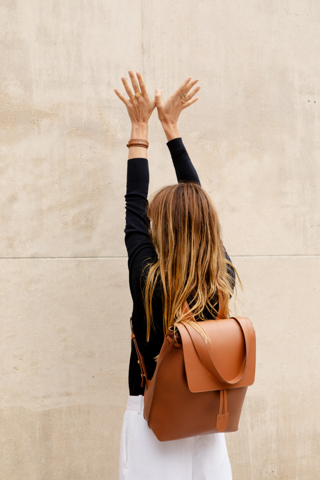 Femme portant le sac à dos Ysé ENVOL camel bras levés #Couleur_Camel