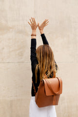 Femme portant le bracelet Billie ENVOL camel avec le sac à dos Ysé camel #Couleur_Camel