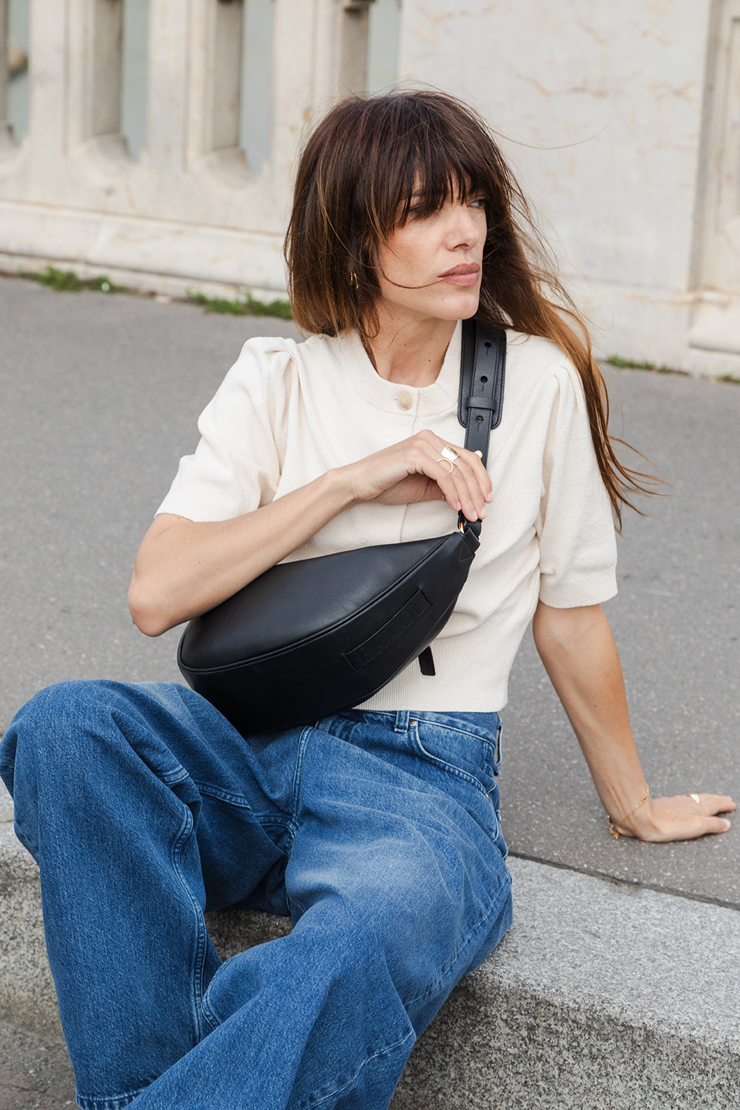 Femme portant le sac banane Thelma ENVOL noir assise #Couleur_Noir