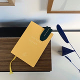 Marque-page Charlie ENVOL vert sapin dans un livre #Couleur_Vert Sapin